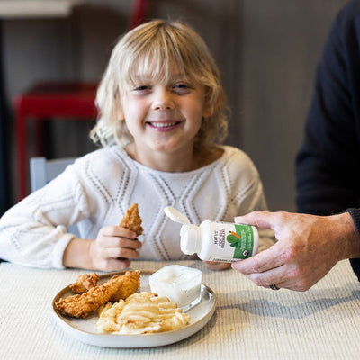 child smiling as product is added to her plate